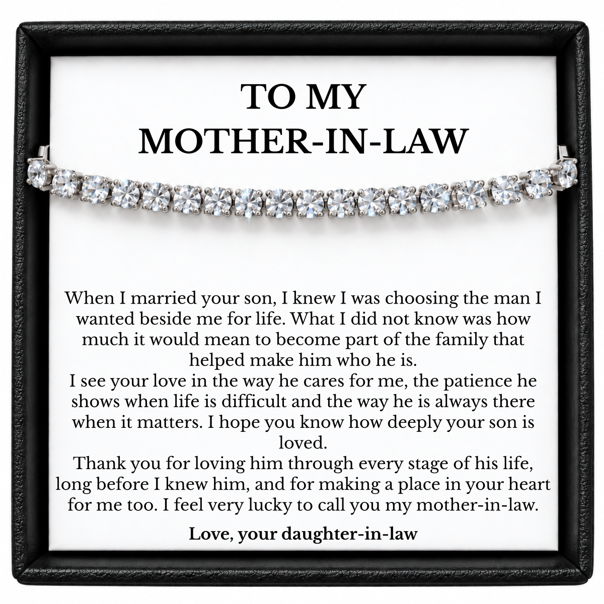 Silver-tone tennis bracelet across a white mother-in-law message card from her daughter-in-law in a black gift box.
