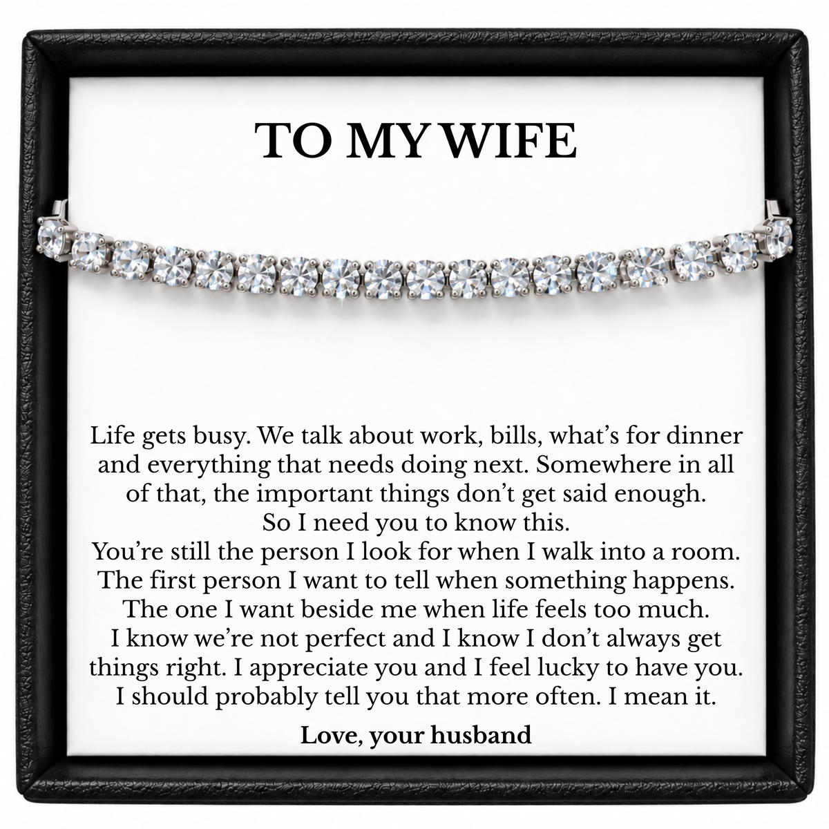 Silver-tone tennis bracelet across a “To My Wife” message card in a black gift box.
