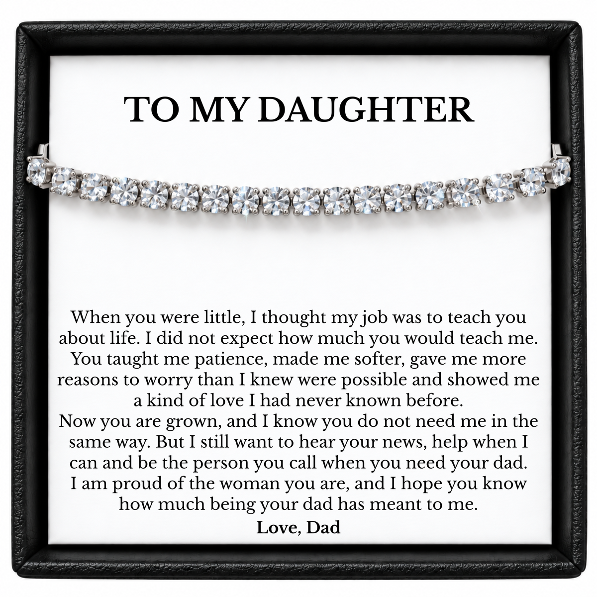 Silver-coloured tennis bracelet across a To My Daughter message card signed Love, Dad, inside a black gift box.