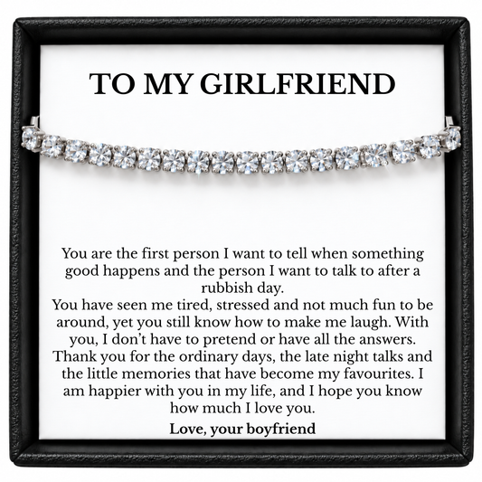 Silver colour tennis bracelet displayed across a To My Girlfriend message card from her boyfriend inside a black gift box.