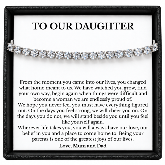 Silver-tone tennis bracelet across a To Our Daughter message card from Mum and Dad inside a black gift box