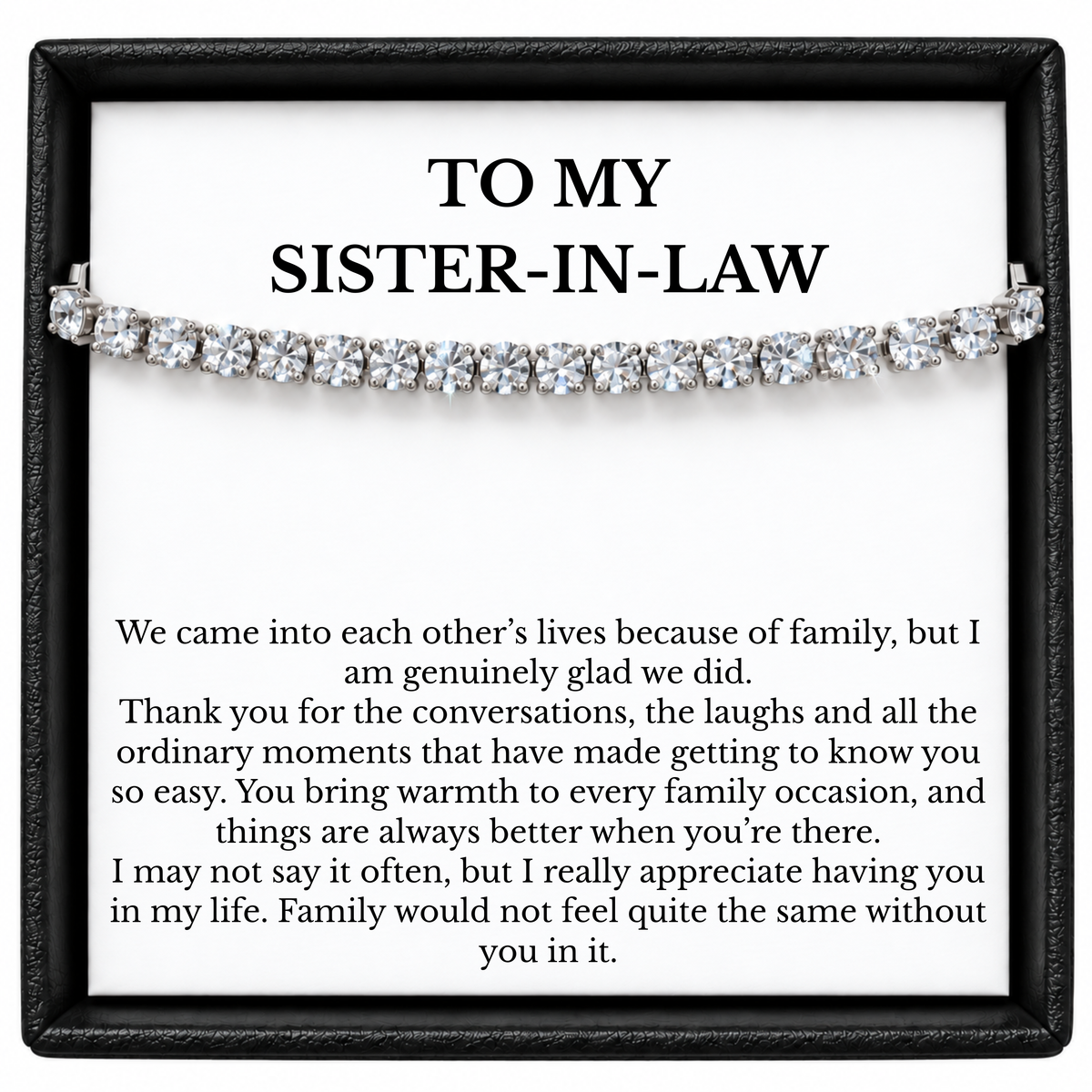 Tennis bracelet with clear round stones across a sister-in-law message card inside a black gift box.
