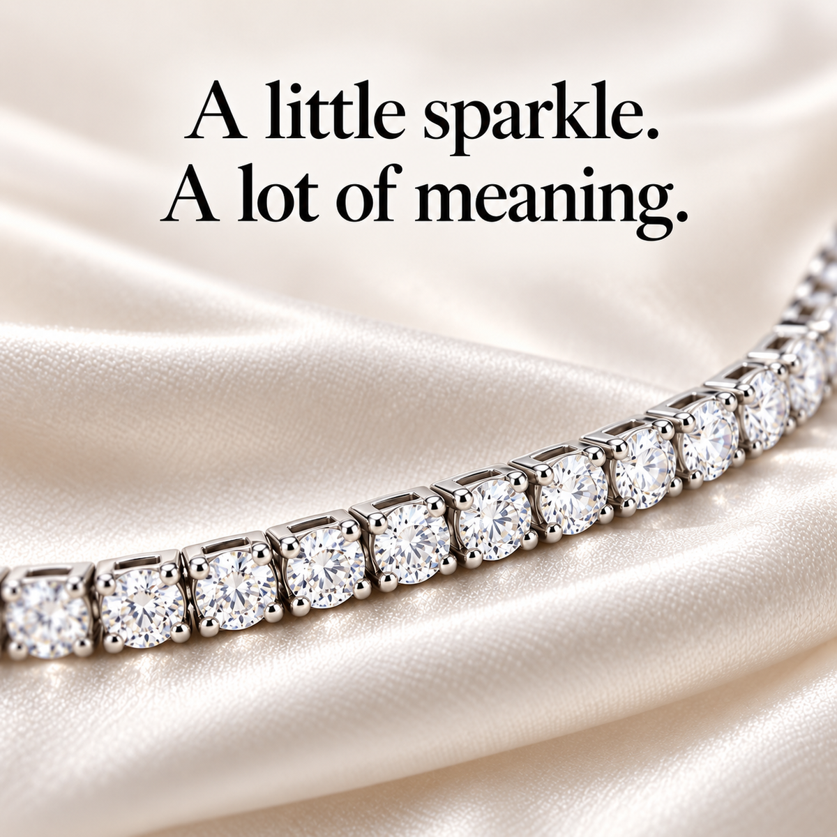 Close-up of the tennis bracelet's clear round stones and silver-tone settings on cream fabric.