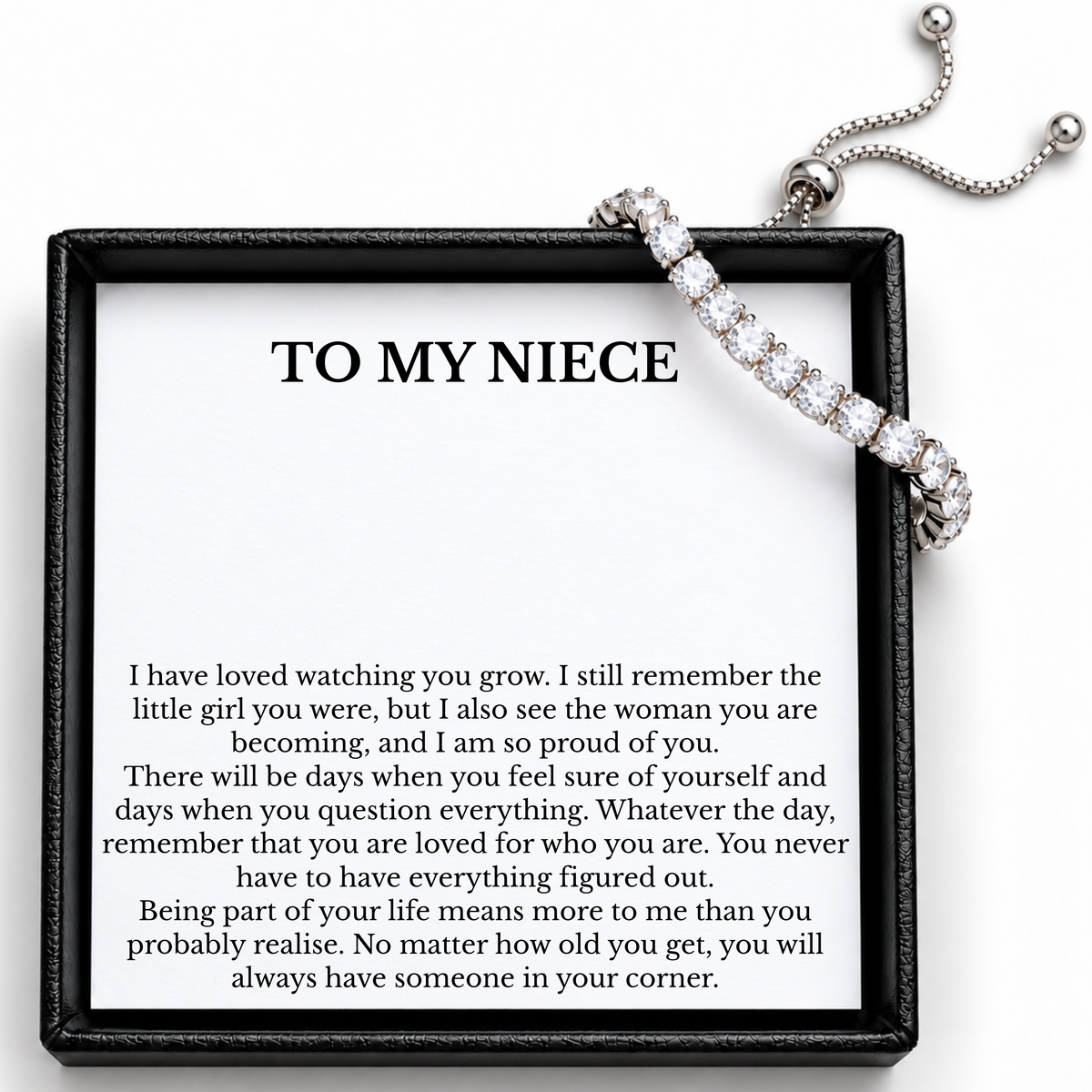 Silver-coloured tennis bracelet draped over a To My Niece card, showing its adjustable slider and chain ends.