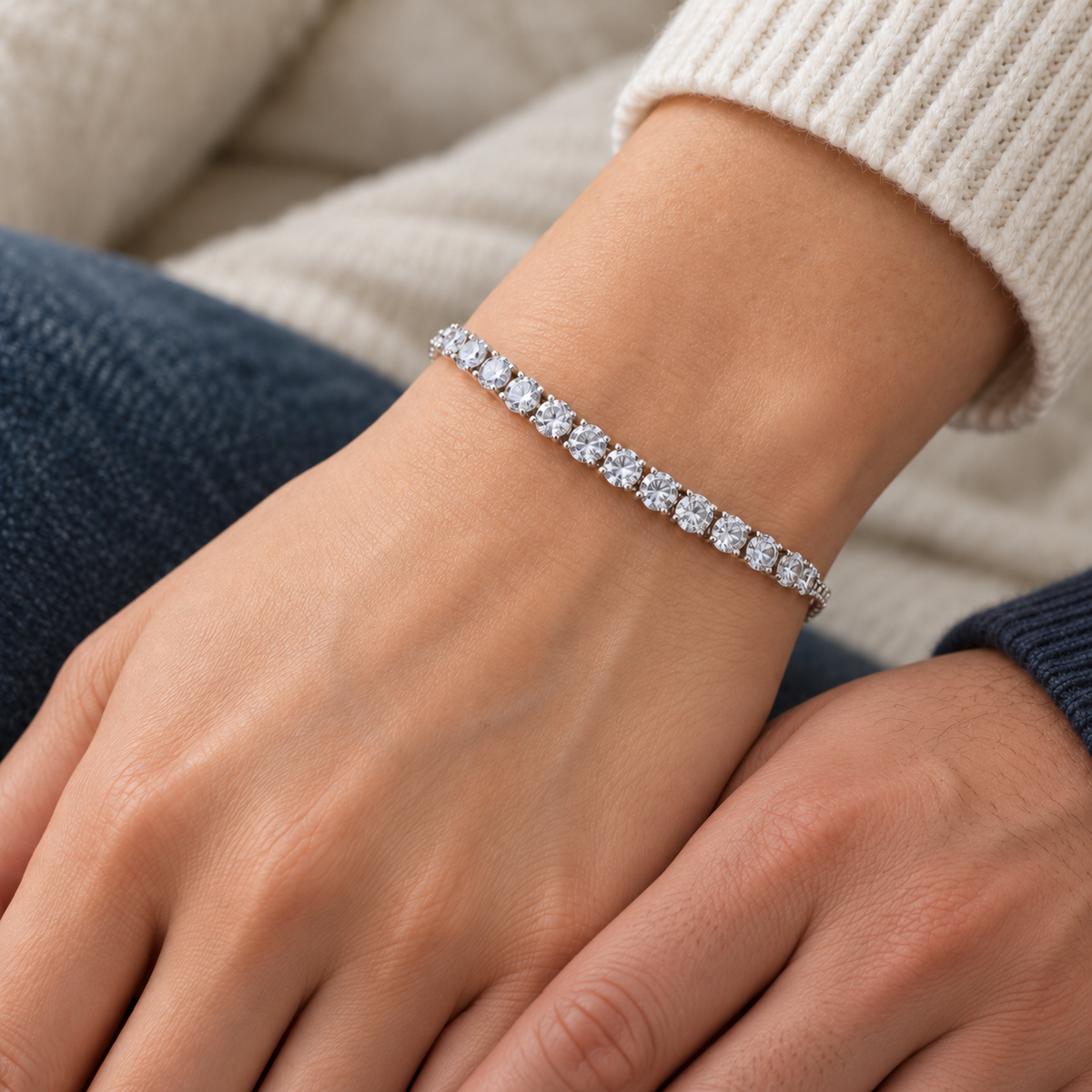 Silver-coloured tennis bracelet with clear round stones worn on a woman's wrist