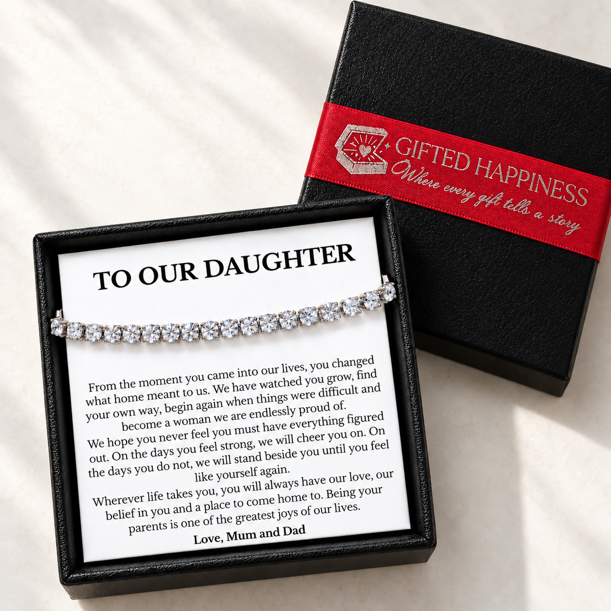 Daughter bracelet and message card in an open black gift box beside the lid with Gifted Happiness red ribbon