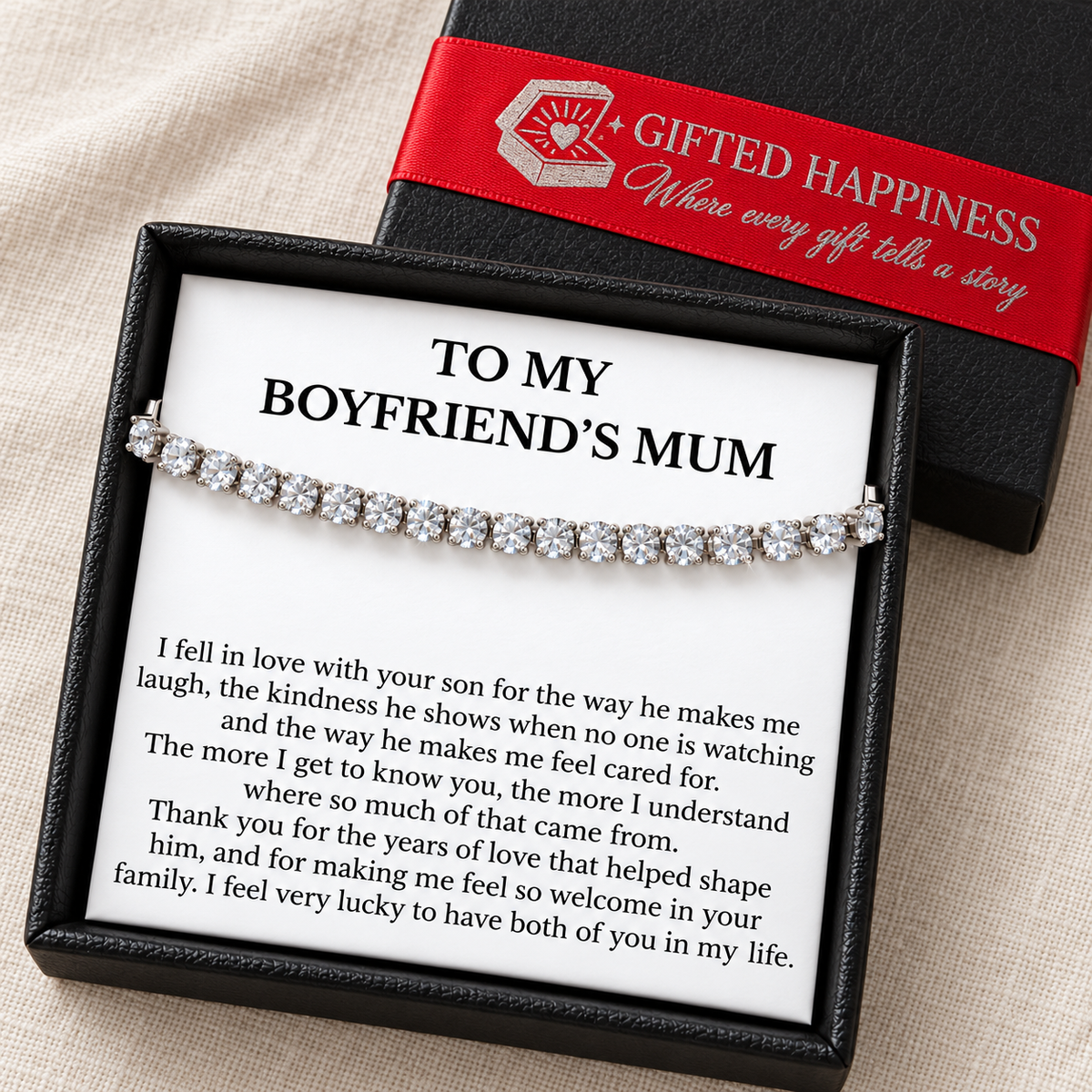 Tennis bracelet and boyfriend's mum message card in a black gift box beside its lid with Gifted Happiness red ribbon.