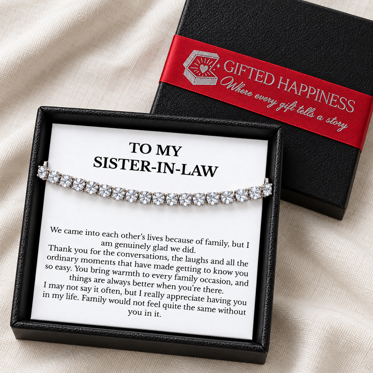 Sister-in-law bracelet and message card in a black gift box beside its lid with red Gifted Happiness ribbon.